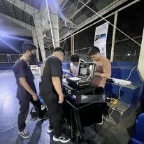 The TINKIT team around a portable network kit at an indoor court