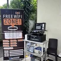 A FREE WIFI ZONE standee beside TINKIT's portable network kit at a wedding venue