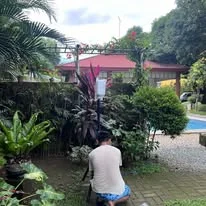 A TINKIT technician setting up equipment at a poolside events venue