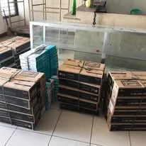 Boxed monitors and computers stacked in a school room