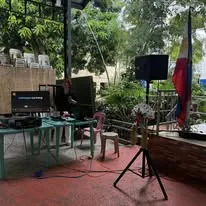 A screen, speaker and laptop set up on a garden patio